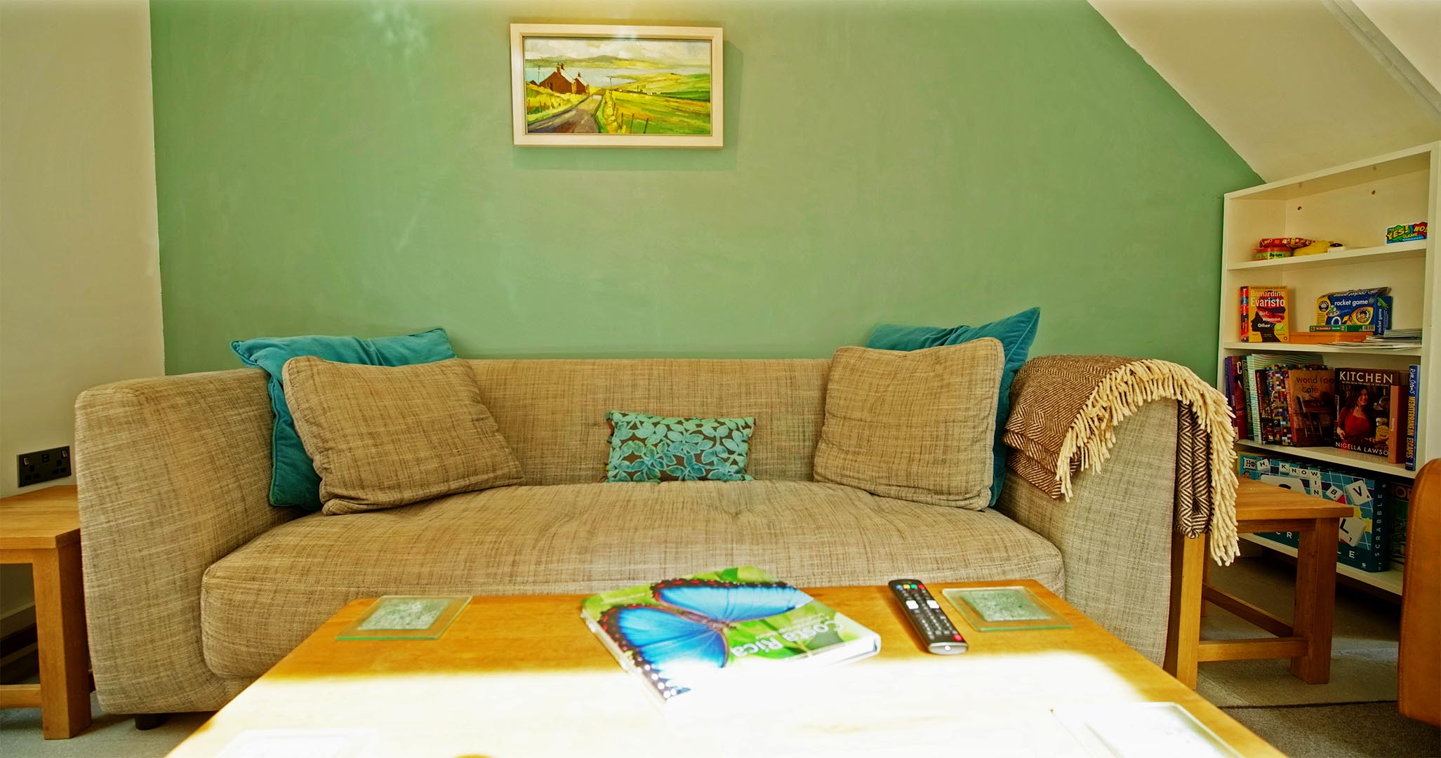 The large sofa with original painting above at Fernleigh Courtyard a 2-bedroom holiday cottage in the Wye Valley.