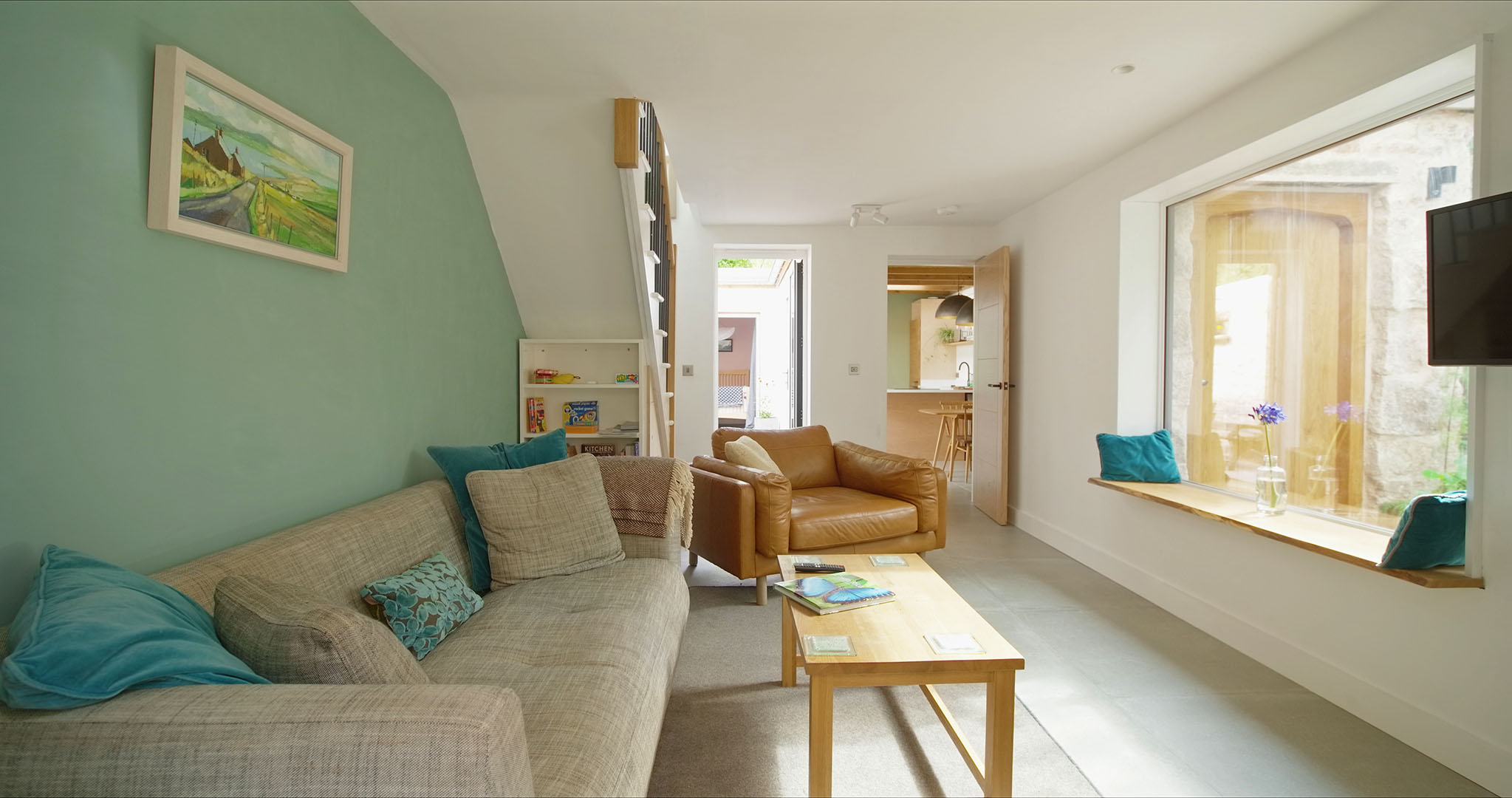 The lounge at Fernleigh Courtyard with view through the picture window to front door & beyond, the kitchen-diner.