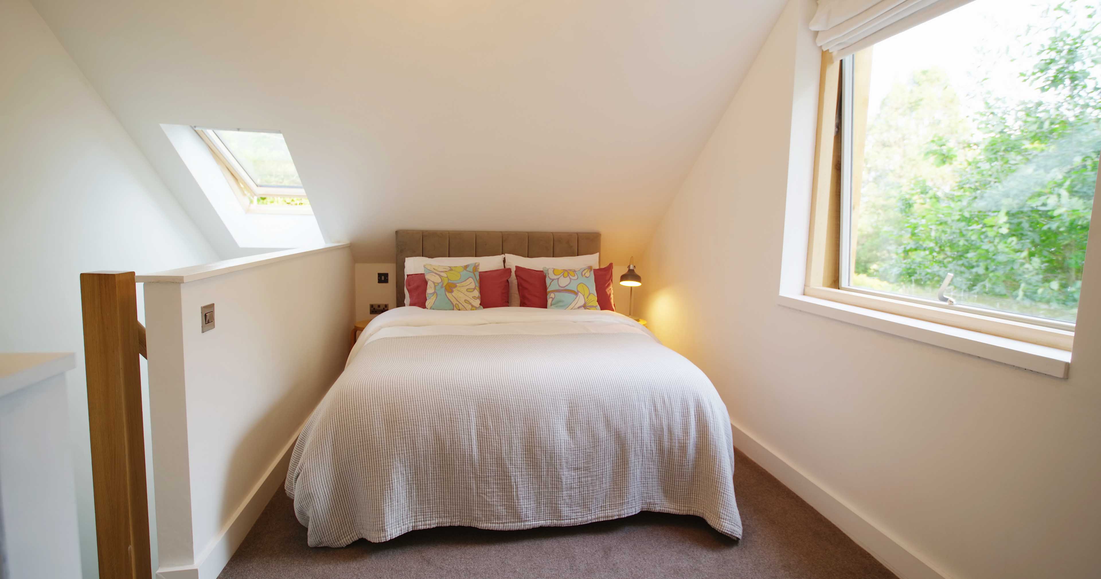 First floor bedroom with king size bed and large picture window at Fernleigh Courtyard luxury holiday cottage, Wye Valley.